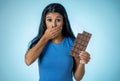Beautiful young cute and happy latin woman in casual clothes holding big delicious chocolate tablet looking with temptation Royalty Free Stock Photo