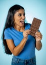 Beautiful young cute and happy latin woman in casual clothes holding big delicious chocolate tablet looking with temptation Royalty Free Stock Photo