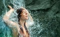 beautiful young cute sexy redhead woman in bikini enjoying relaxed the splashing water of the waterfall in the Spa Wellness, feels