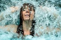 Beautiful young cute sexy redhead woman under the splashing falling water shower waterfall in the Spa Wellness pool Royalty Free Stock Photo