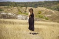 Beautiful young dark haired woman in black dress walk in field. Pretty girl  outdoor in the field enjoy with freedom Royalty Free Stock Photo