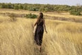 Beautiful young dark haired woman in black dress walk in field. Pretty girl  outdoor in the field enjoy with freedom Royalty Free Stock Photo