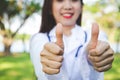 Beautiful young doctor, thumbs up, likes to maintain health. Royalty Free Stock Photo