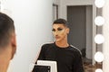 Young drag queen makeup artist looking at himself in front of the mirror Royalty Free Stock Photo