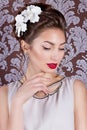 Beautiful young elegant girl with bright makeup with red lips with a beautiful wedding hairstyle for the bride with white flowers Royalty Free Stock Photo