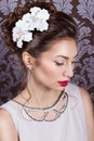 Beautiful young elegant girl with bright makeup with red lips with a beautiful wedding hairstyle for the bride with white flowers Royalty Free Stock Photo