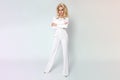 Beautiful Young elegant tall woman businesswoman standing on a white background of white pants and blouse Royalty Free Stock Photo