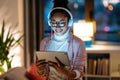 Beautiful young entrepreneur woman using her digital tablet while listening music standing in the office Royalty Free Stock Photo