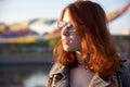 Beautiful young woman with red hair in the park. Sunlight. Portrait of a smiling red-haired girl in a park in the last rays. Very