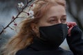 Beautiful young European woman in spring clothes on the street with a medical face mask on. coronavirus - Covid19 Royalty Free Stock Photo