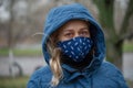 Beautiful young European woman in spring clothes on the street with a medical face mask on. coronavirus - Covid19 Royalty Free Stock Photo