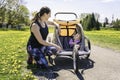 Beautiful young family with baby in jogging stroller running outside in summer season Royalty Free Stock Photo