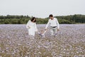 Beautiful young family with a boy resting in a field of flowers. Royalty Free Stock Photo