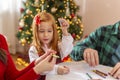 Young family with children drawing with crayons on Christmas day