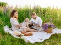 Beautiful young family dad and mom with a little baby girl sitting on a picnic Royalty Free Stock Photo