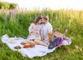 Beautiful young family dad and mom with a little baby girl sitting on a picnic Royalty Free Stock Photo