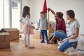 Beautiful young family having fun, playing in new apartment, still unpacked