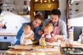 Young family making cookies at home. Royalty Free Stock Photo