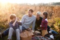 Beautiful young family with small children having picnic in autumn nature. Royalty Free Stock Photo