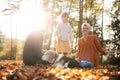 Beautiful young family with small daughter and dog sitting in autumn forest. Royalty Free Stock Photo