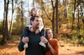 Beautiful young family with small daughter on a walk in autumn forest. Royalty Free Stock Photo