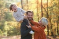 Beautiful young family with small daughter on a walk in autumn forest. Royalty Free Stock Photo