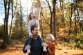 Beautiful young family with small daughter on a walk in autumn forest. Royalty Free Stock Photo