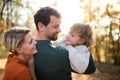 Beautiful young family with small daughter on a walk in autumn forest. Royalty Free Stock Photo