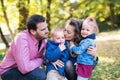 Beautiful young family with small twins on a walk in autumn forest, kissing. Royalty Free Stock Photo