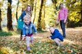 Beautiful young family with small twins on a walk in autumn forest, playing. Royalty Free Stock Photo