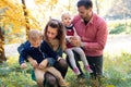 Beautiful young family with small twins on a walk in autumn forest. Royalty Free Stock Photo