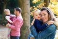 Beautiful young family with small twins on a walk in autumn forest, standing. Royalty Free Stock Photo