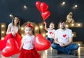 Beautiful young family and their little kids pose with balloons in a cosy studio. Royalty Free Stock Photo