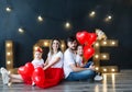 Beautiful young family and their little kids pose with balloons in a cosy studio. Studio family portrait. Royalty Free Stock Photo