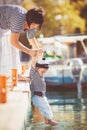 Beautiful young family of two walking along wooden jetty. Woman with son on pier Royalty Free Stock Photo