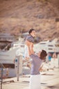 Beautiful young family of two walking along wooden jetty. Woman with son on pier Royalty Free Stock Photo