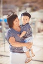 Beautiful young family of two walking along wooden jetty. Woman with son on pier Royalty Free Stock Photo