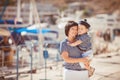 Beautiful young family of two walking along wooden jetty. Woman with son on pier Royalty Free Stock Photo