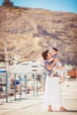 Beautiful young family of two walking along wooden jetty. Woman with son on pier Royalty Free Stock Photo