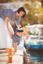 Beautiful young family of two walking along wooden jetty. Woman with son on pier Royalty Free Stock Photo