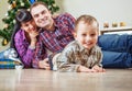 Beautiful young family under the christmas tree at home