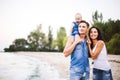 Beautiful young family on vacation with baby. The father holds the blonde girl in her arms, and the brunette`s mother hugs her hu Royalty Free Stock Photo