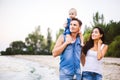 Beautiful young family on vacation with baby. The father holds the blonde girl in her arms, and the brunette`s mother hugs her hu Royalty Free Stock Photo