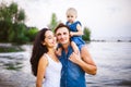 Beautiful young family on vacation with baby. The father holds the blonde girl in her arms, and the brunette`s mother hugs her hu Royalty Free Stock Photo