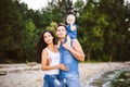 Beautiful young family on vacation with baby. The father holds the blonde girl in her arms, and the brunette`s mother hugs her hu Royalty Free Stock Photo