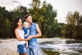 Beautiful young family on vacation with baby. The father holds the blonde girl in her arms, and the brunette`s mother hugs her hu Royalty Free Stock Photo