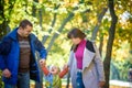 Beautiful young family on a walk in autumn forest on maple yellow trees background. Father and mother hold son on hands. Happy fa Royalty Free Stock Photo