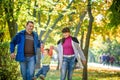 Beautiful young family on a walk in autumn forest on maple yellow trees background. Father and mother hold son on hands. Happy Royalty Free Stock Photo