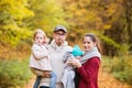 Beautiful young family on a walk in autumn forest. Royalty Free Stock Photo