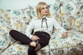 Beautiful young fashion caucasian blonde model posing on sofa. Royalty Free Stock Photo